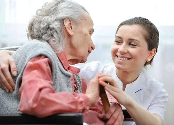 Caregiver smiling with an elderly woman
